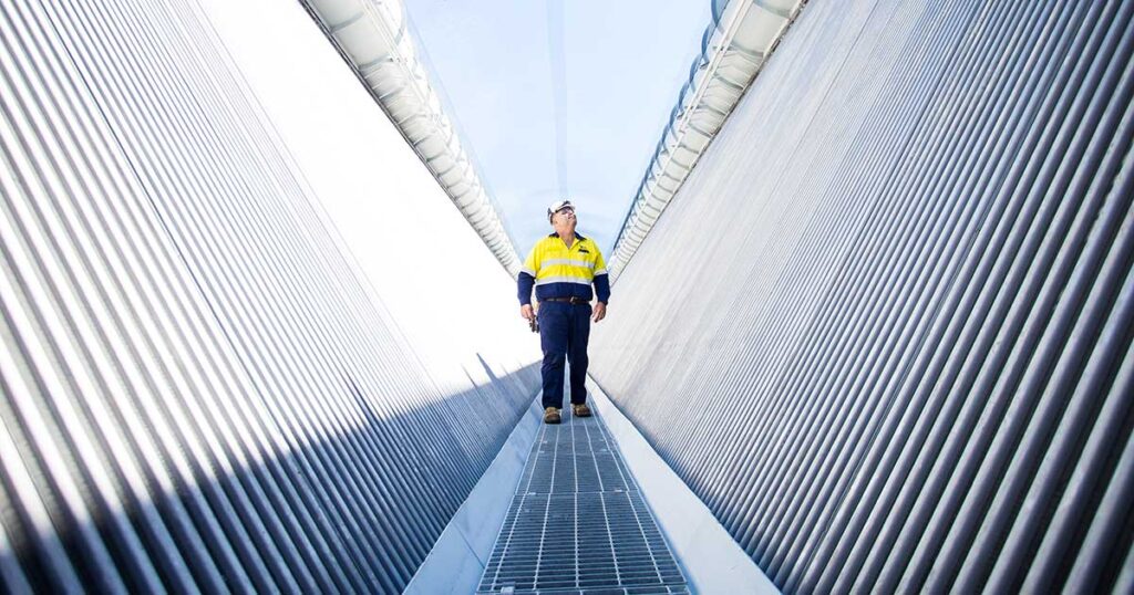 CS Energy employee walking on the top level of the air-cooled condenser